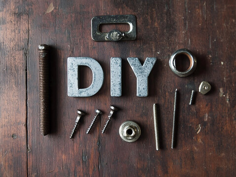 Creative arrangement of metal fasteners, tools, and letters expressing DIY spirit on wooden surface