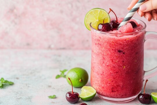 Refreshing cherry smoothie adorned with lime slices and mint lea