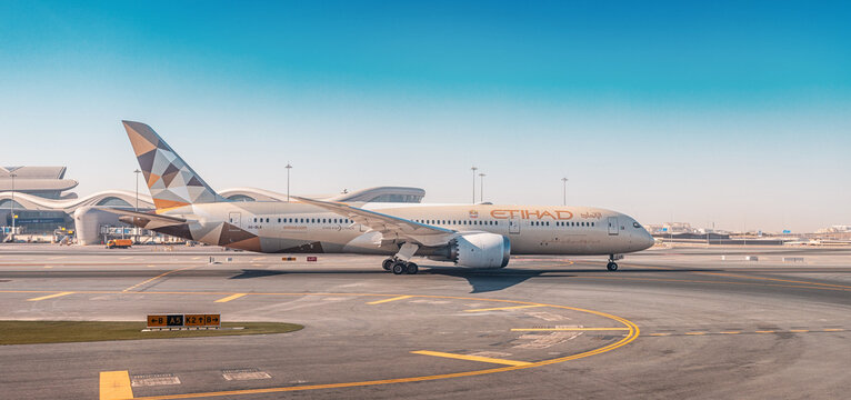 23 January 2025, Abu Dhabi, UAE: Etihad airplane taxiing on the runway of AUH airport, ready for departure under a clear blue sky