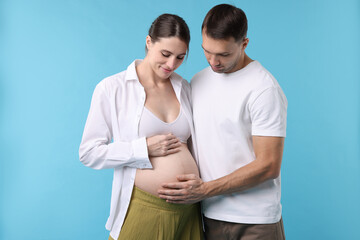 Fototapeta premium Pregnant woman and her husband on blue background