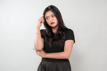 An Indonesian woman with long black hair wearing a black outfit, expressing confusion and deep...