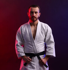 Karate fighter wearing uniform in color lights