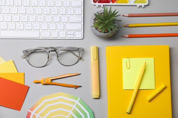 Designer's workplace. Flat lay composition with stationery and keyboard on light grey background