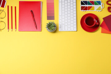 Designer's workplace. Flat lay composition with stationery, keyboard and cup of coffee on yellow...