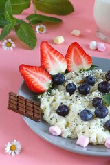 Delicious breakfast with semolina, blueberries and marshmallows on a pink background