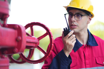 Male engineer inspects water pipelines in the engineering system area of the factory outside where...