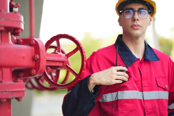 Male engineer inspects water pipelines in the engineering system area of the factory outside where various pipelines are designed modernly. Technicians work in the industry.