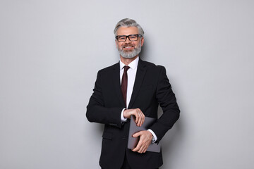 Portrait of banker with laptop on grey background
