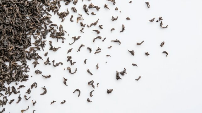 Loose dried black tea leaves scattered on a white background white background with empty space ready for copy
