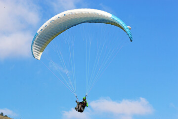Paraglider flying in a blue sky	