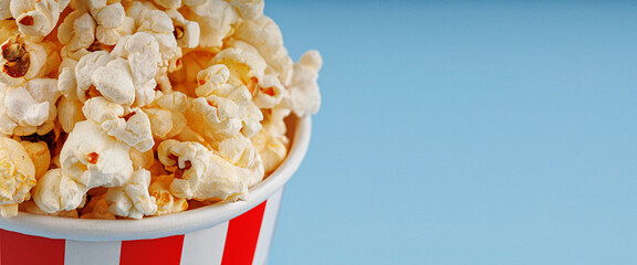 Classic red striped popcorn cardboard cup on blue background