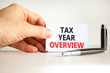 Tax year overview symbol. Concept words Tax year overview on beautiful white card. Beautiful white background. Businessman hand. Business tax year overview concept. Copy space.