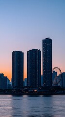 Obraz premium Skyline Serenity: A trio of towering buildings stand majestically against a backdrop of a captivating twilight sky over a serene body of water.