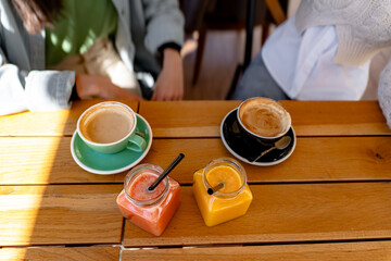 Coffee and Fruit Smoothies Resting on a Wooden Table in a Cafe