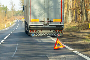 truck breakdown.broken truck with semi-trailer on national road. warning triangle displayed on the...