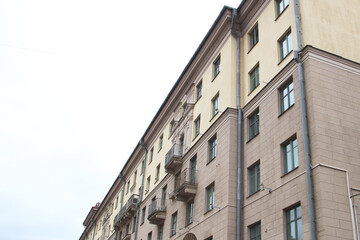 I gaze at a tall building adorned with balconies and windows