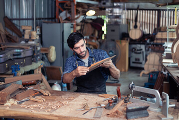 Luthier making top of guitar using traditional tools in workroom with manual tools