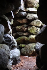 Ancient Stone Passageway with Mossy Rocks in a Natural Cave