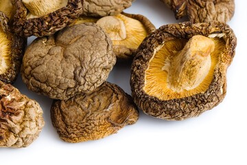 Dried shiitake mushrooms arranged on a pure white background, emphasizing detailed textures and natural colors.