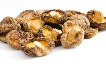 Rustic dried shiitake mushrooms set on a white background, revealing their unique texture and natural flavor.