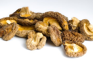Rustic dried shiitake mushrooms set on a white background, revealing their unique texture and natural flavor.
