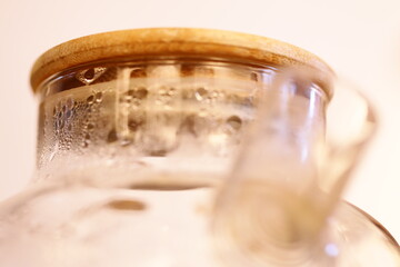 A close-up shot of a glass jar with a wooden lid, suitable for use in still life or product photography.