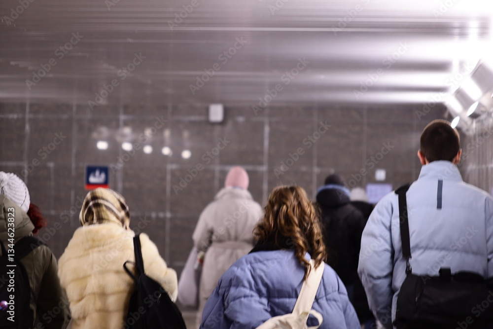 Poster group of people walking through a busy train station, possibly heading to work or on a daily commute