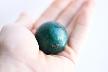 A person grasping a green marble ball in their hand, a simple yet thought-provoking image.