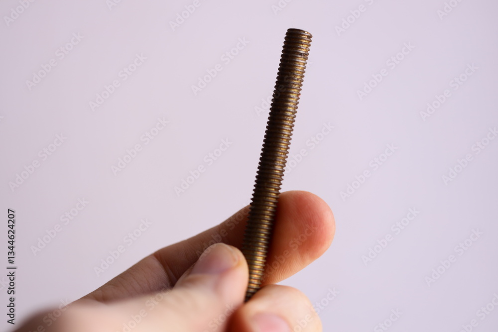 Aufkleber a person holding a screw, useful for diy projects or demonstrating tool usage.
