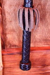 A close-up shot of a leather handle on a wooden door, suitable for use in interior design or architecture settings.