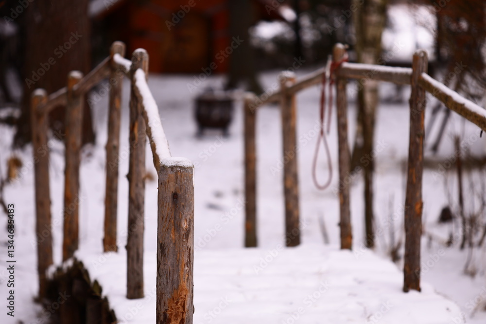 Poster a rustic wooden bridge set against a backdrop of snowy trees and a bench, perfect for winter scenes 