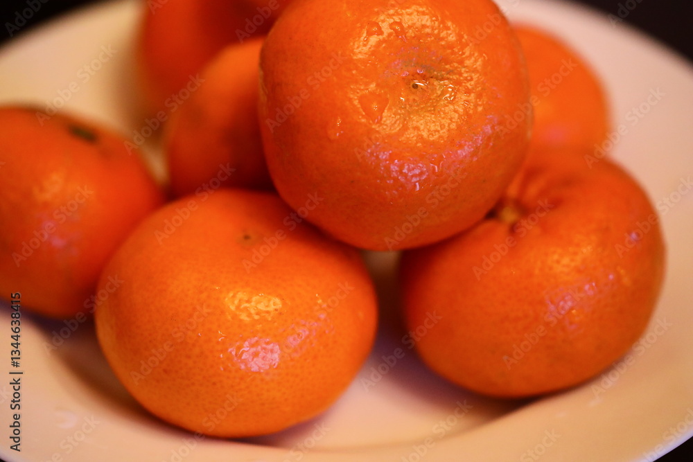 Poster a simple still life composition featuring a white plate topped with oranges on a table.
