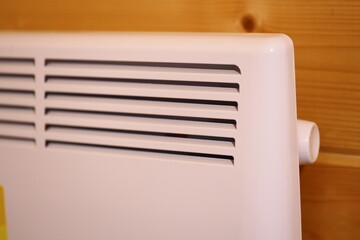 A detailed view of a heater mounted on a wooden wall, suitable for use in interior design and home decor images.