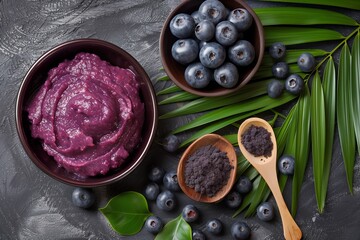 A creamy blueberry smoothie bowl with fresh blueberries, berry powder, and palm leaves, arranged on a textured dark background, showcasing natural colors and textures.