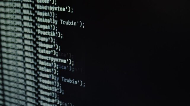 Blurry fast-moving lines of code appear on a screen, creating a futuristic Matrix-style effect, symbolizing hacking, data processing, or AI. A close-up shot of a computer screen.