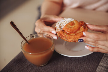 woman having breakfast with croissant and coffee
