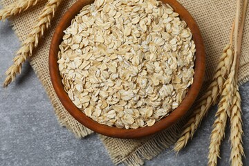 Composition with oatmeal flakes on gray background. Cooking breakfast