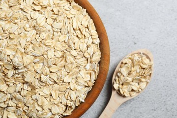 Composition with oatmeal flakes on gray background. Cooking breakfast