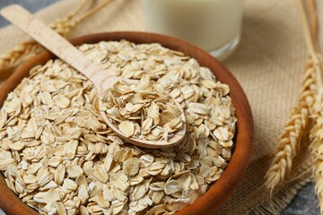 Composition with oatmeal flakes on gray background. Cooking breakfast