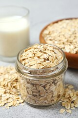 Composition with oatmeal flakes on gray background. Cooking breakfast