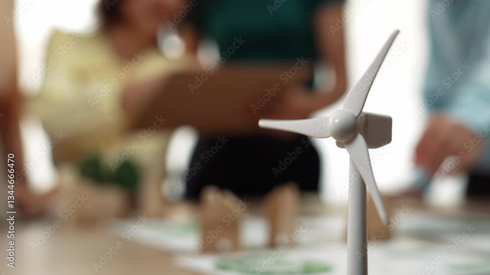 Poster windmill model represented using green energy and wooden block symbolized eco house was on table in 