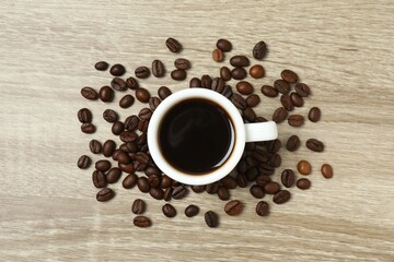 Cup of coffee and coffee beans on wooden background