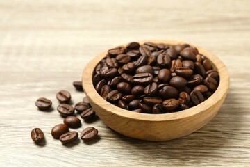 Wooden bowl with coffee beans on wooden background