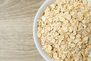 Composition with oatmeal flakes on wooden background. Cooking breakfast