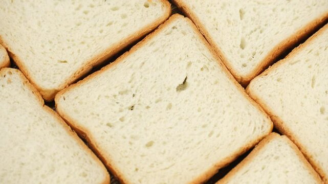 Zoom frame Sliced Freshly Baked toast bread on wooden board, rotation