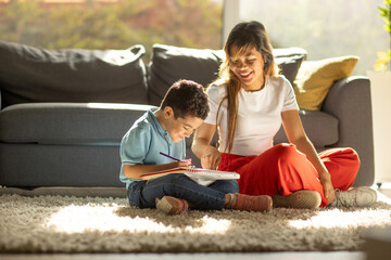 Boy sitting on a carpet with his mother