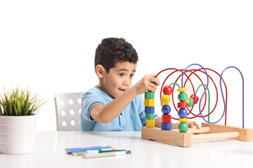 Boy sitting and playing with a logic toy bead maze