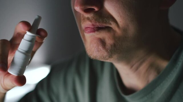 Stuffy nose during flu.
A man with a cold puts drops in his nose.
A nasal spray in a man's hands.
A man treats a runny nose
