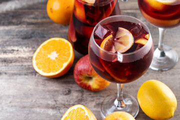 Refreshing Summer Citrus Fruit Sangria in crystal jar on wooden table. Copy space