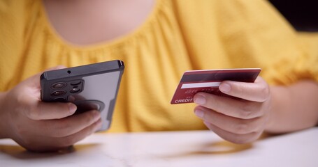 Online shopping action user engaging with smartphone and credit card modern home setting